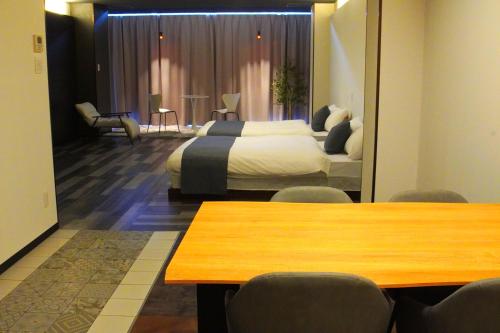 a hotel room with a bed and a table and chairs at Kototoki-Ren-201 Superior Twin room in Hiroshima