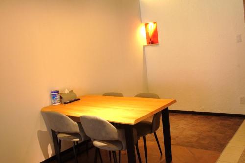 a wooden table with chairs and a light on the wall at Kototoki-Ren-201 Superior Twin room in Hiroshima