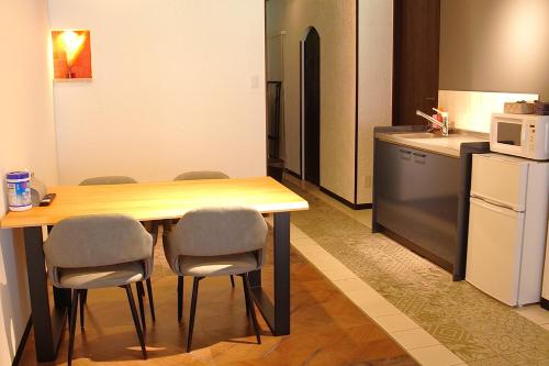 a kitchen with a table and chairs and a refrigerator at Kototoki-Ren-201 Superior Twin room in Hiroshima