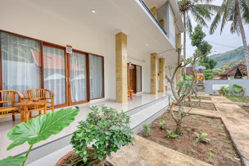 a house with a patio with a table and some plants at Jasipa Penida Villa in Nusa Penida