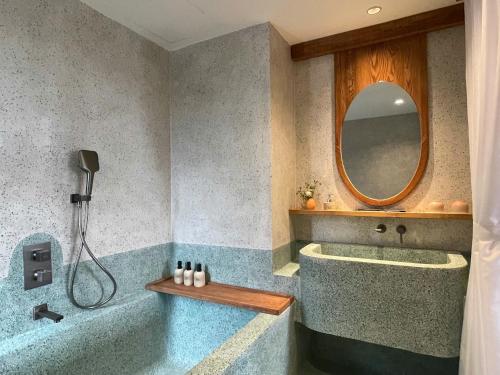 a bathroom with a tub and a mirror at The Pink Boutique Hotel in Da Lat