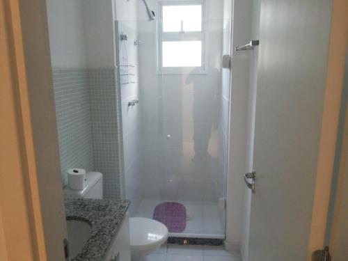 a bathroom with a shower with a toilet and a sink at Apartamento Porto Real Brites in Mangaratiba