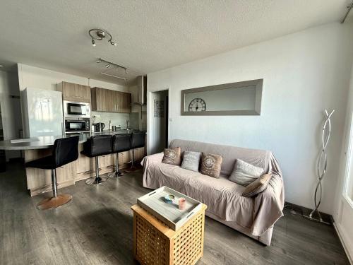 un salon avec un canapé et une cuisine dans l'établissement Appartement familial avec vue sur mer, parking privé - FR-1-652-24, à Saint-Hilaire-de-Riez