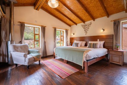 a bedroom with a bed and a chair at Unuwasi Hotel & Villa in Calca