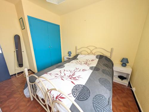 - une chambre avec un lit et une porte bleue dans l'établissement Charmant T2 proche plage à Port-la-Nouvelle, terrasse et parking inclus - FR-1-797-29, à Port-la-Nouvelle