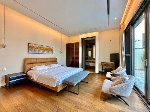 a bedroom with a bed and two chairs at Sanya Haitang Bay Ocean State International Resort Hotel in Sanya