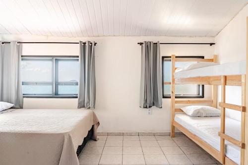 a bedroom with two bunk beds and a window at Beira-Mar Guest House in Arraial do Cabo