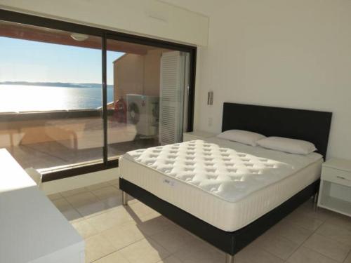 une chambre avec un lit avec vue sur l'océan dans l'établissement Appartement 3 pièces avec piscine et climatisation à Sainte-Maxime - FR-1-780-62, à Sainte-Maxime