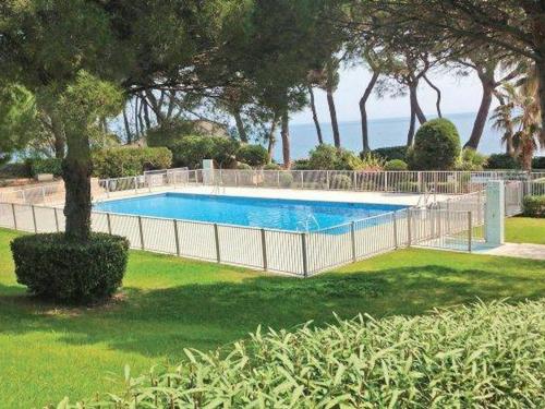 une clôture autour d'une piscine dans une cour dans l'établissement Appartement 4P avec piscine, garage et climatisation à Sainte-Maxime - FR-1-780-68, à Sainte-Maxime