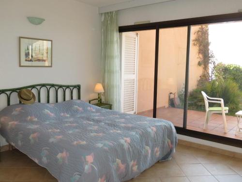 une chambre avec un lit et une porte coulissante en verre dans l'établissement Appartement 4P avec piscine, garage et climatisation à Sainte-Maxime - FR-1-780-68, à Sainte-Maxime