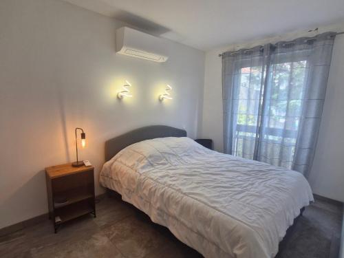 - une chambre avec un lit et deux lumières sur le mur dans l'établissement Appartement 2 pièces climatisé, parking privé, centre Sainte-Maxime, animaux acceptés - FR-1-780-26, à Sainte-Maxime