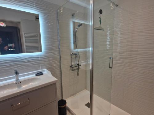 une salle de bain avec une douche en verre et un lavabo dans l'établissement Sainte-Maxime : Appartement moderne pour 4 personnes - FR-1-780-86, à Sainte-Maxime