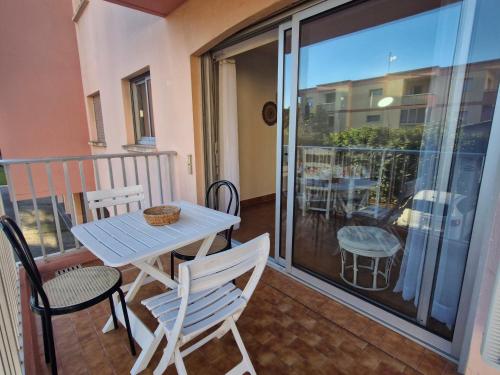 un patio avec une table et des chaises sur un balcon dans l'établissement Sainte-Maxime : Appartement moderne pour 4 personnes - FR-1-780-86, à Sainte-Maxime