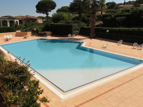 une grande piscine bleue dans une cour dans l'établissement Appartement 2 pièces avec jardin, garage et piscine à Sainte-Maxime - FR-1-780-45, à Sainte-Maxime