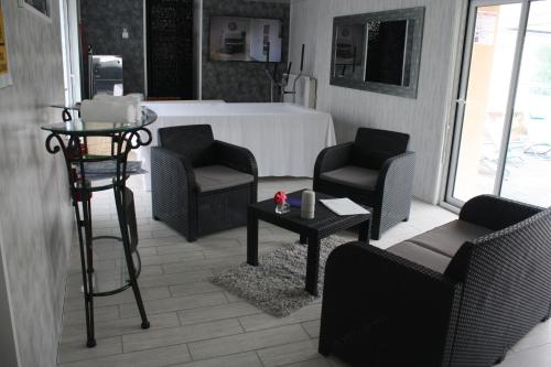 - un salon avec des chaises et une table dans l'établissement Logis Hotel & restaurant Le Relais De Fleurette, à Pontavert