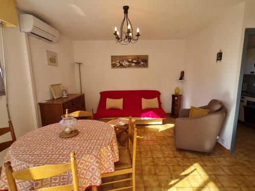 - un salon avec une table et un lit rouge dans l'établissement Appartement 2 Pièces Climatisé avec Parking en Centre-Ville, Proche Plages - Sainte-Maxime - FR-1-780-54, à Sainte-Maxime