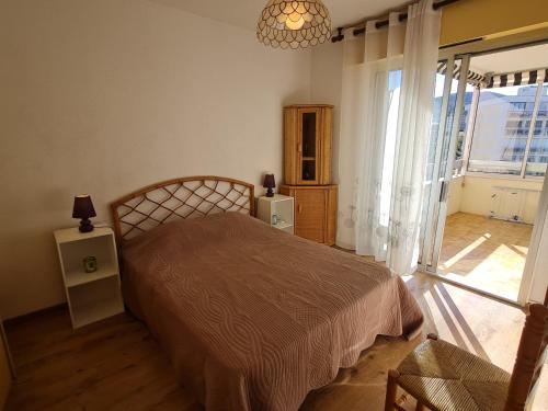 une chambre avec un lit et une grande fenêtre dans l'établissement Appartement 2 Pièces Climatisé avec Parking en Centre-Ville, Proche Plages - Sainte-Maxime - FR-1-780-54, à Sainte-Maxime