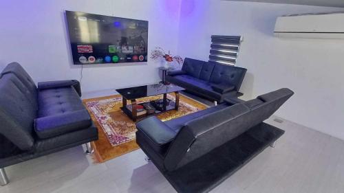 a living room with two couches and a flat screen tv at Cai Âirbnb - An affordable comfortable hideout with fully AC in Santa Rosa