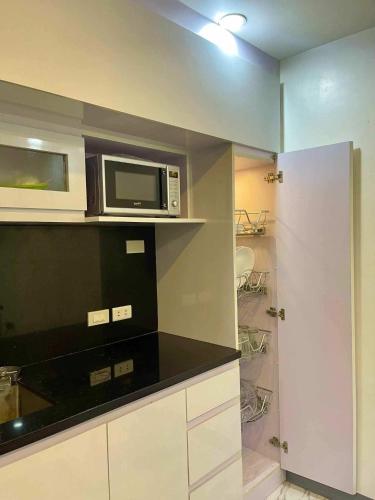 a kitchen with a microwave on top of a counter at Cai Âirbnb - An affordable comfortable hideout with fully AC in Santa Rosa