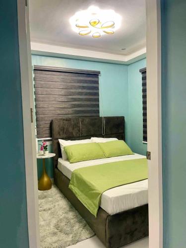 a bedroom with a bed with a green comforter at Cai Âirbnb - An affordable comfortable hideout with fully AC in Santa Rosa