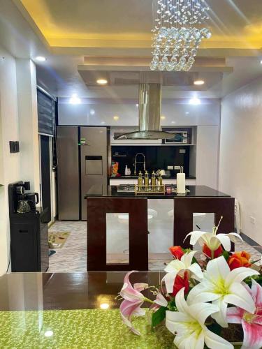 a kitchen with a glass table with flowers on it at Cai Âirbnb - An affordable comfortable hideout with fully AC in Santa Rosa