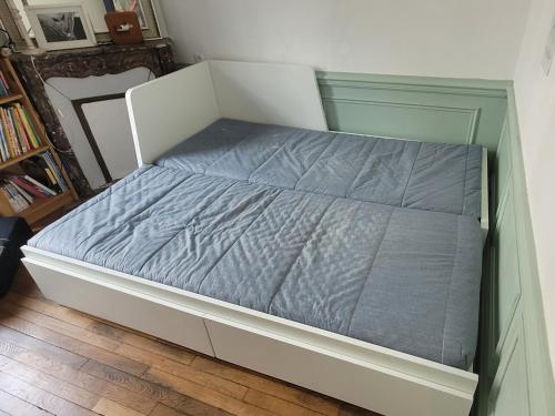 a bed with a blue comforter in a bedroom at Le Fiacre in Nancy