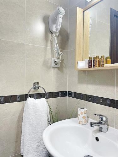 a bathroom with a sink and a hair dryer at Hrebet House Borovets in Borovets