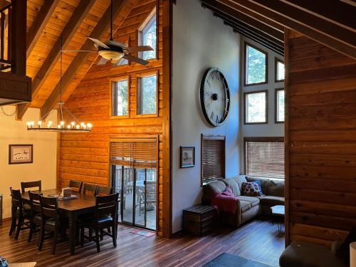 a living room with a table and a clock on the wall at Fully updated Truckee cabin with plenty of beds in Truckee