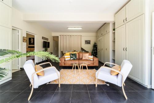 - un salon avec des fauteuils blancs et un canapé dans l'établissement Villa et grand jacuzzi six personnes, en pleine nature, à Saint-Joseph