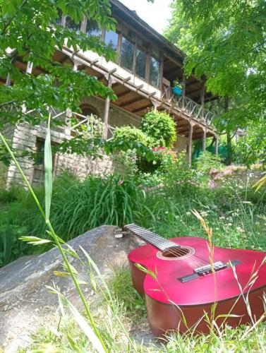 a red guitar sitting on a rock in front of a house at Ejaa's House Bistro & Cafe in Rishīkesh