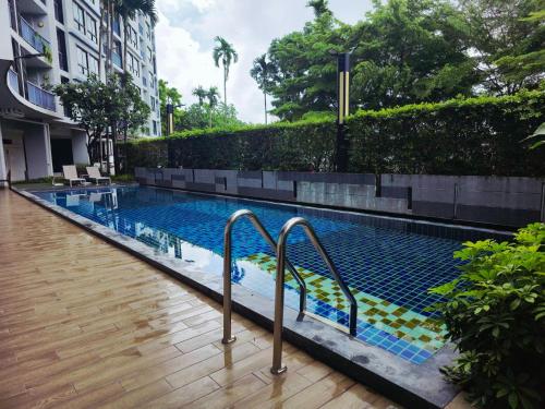 a swimming pool with two metal rails next to a building at Vista Old Town Phuket in Phuket