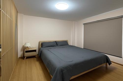 a bedroom with a large bed and a window at Vista Old Town Phuket in Phuket