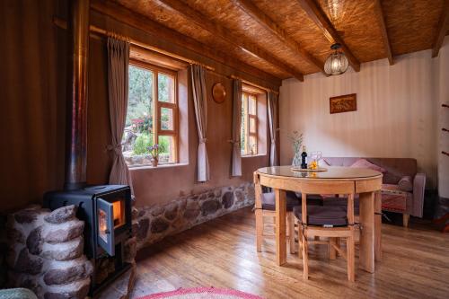 a living room with a table and a wood stove at Unuwasi Hotel & Villa in Calca