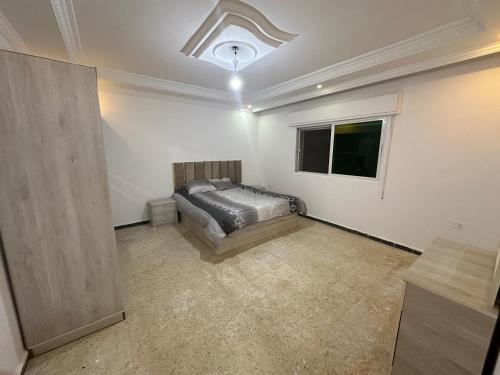 una camera da letto con un letto e una finestra di Beautiful apartment a Irbid