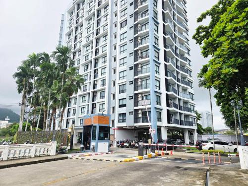 a large white building with a parking lot in front of it at Vista Old Town Phuket in Ban Lo Long