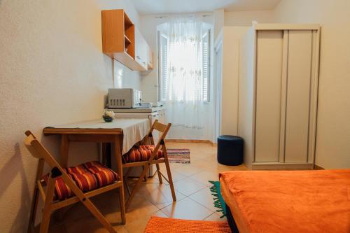 kuchnia ze stołem i krzesłami w pokoju w obiekcie Studio apartman sirena w mieście Zadar