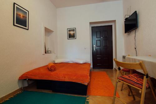 Pokój z łóżkiem ze stołem i drzwiami w obiekcie Studio apartman sirena w mieście Zadar