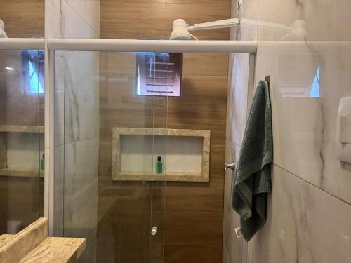 een douche met een glazen deur in een badkamer bij 05 Kitnet próximo da praia com ar-condicionado in Maceió