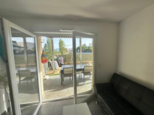 d'un salon avec un canapé et une table ainsi que d'une terrasse. dans l'établissement Appartement Perpignan, à Perpignan