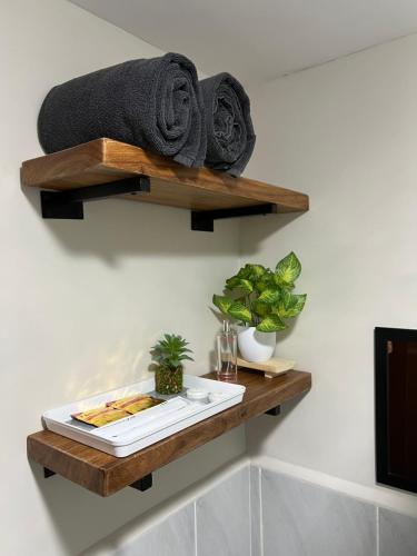 a bathroom with wooden shelves on the wall at Studio Condo in Saekyung Village One Phase3 in Lapu Lapu City