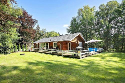 a log cabin in a yard with a grass field at Log Cabin Near Mariager Fjord in Hadsund