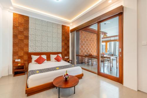 a bedroom with a bed and a table at The Bulih Ubud in Ubud