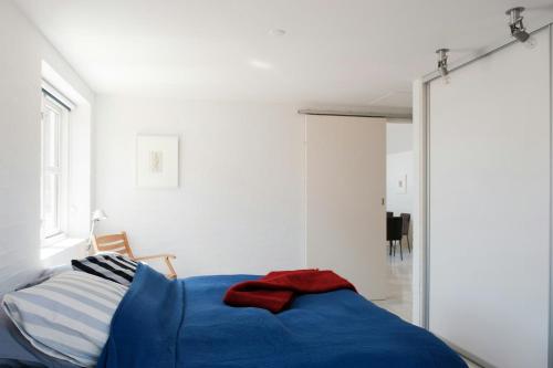 a bedroom with a blue bed and a mirror at Enjoy Sea Views In This Skagen Beach Summer House in Skagen