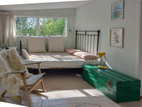 a bed in a room with a window and a chair at Cottage In Woodland Garden In Natural Harmony in Asnæs