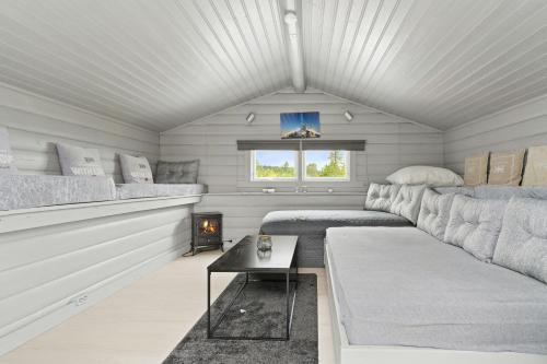 a living room with a couch and a table at Peaceful Cabin With View And Jacuzzi At Blefjell in Kongsberg