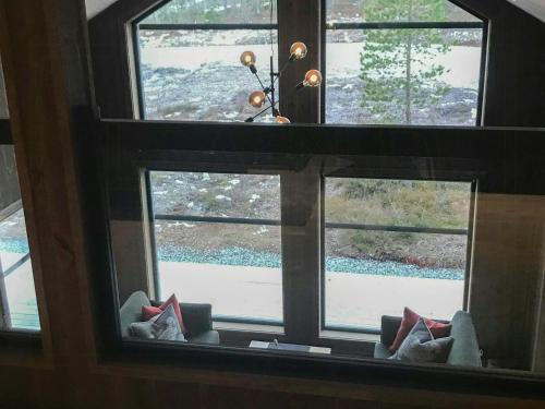 a window in a room looking out at a snow covered yard at Large Cabin Near Hardangervidda With Sunny Veranda in Veggli