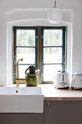 a kitchen counter with a sink and a window at Artistic Gardener's House At Kollerup Estate in Hadsten Stationsby
