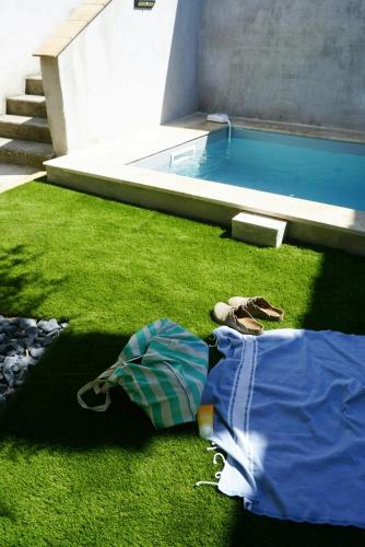 un tas de vêtements sur l'herbe à côté d'une piscine dans l'établissement Historic Bastide In The Heart Of Cathar Country, à Cournanel