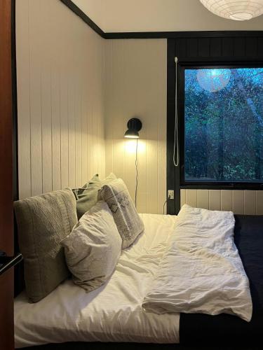 an unmade bed in a room with a window at Birdsong And The Sound Of Waves At Reersø in Gørlev