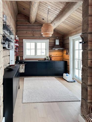 a kitchen with a black counter and wooden walls at Spectacular Cabin With View In Jotunheimen in Eidsbugarden